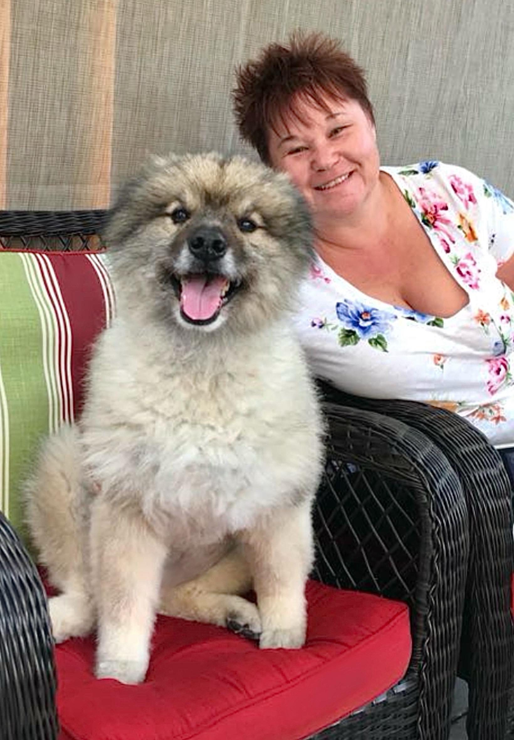 Woman sitting on chair beside her dog